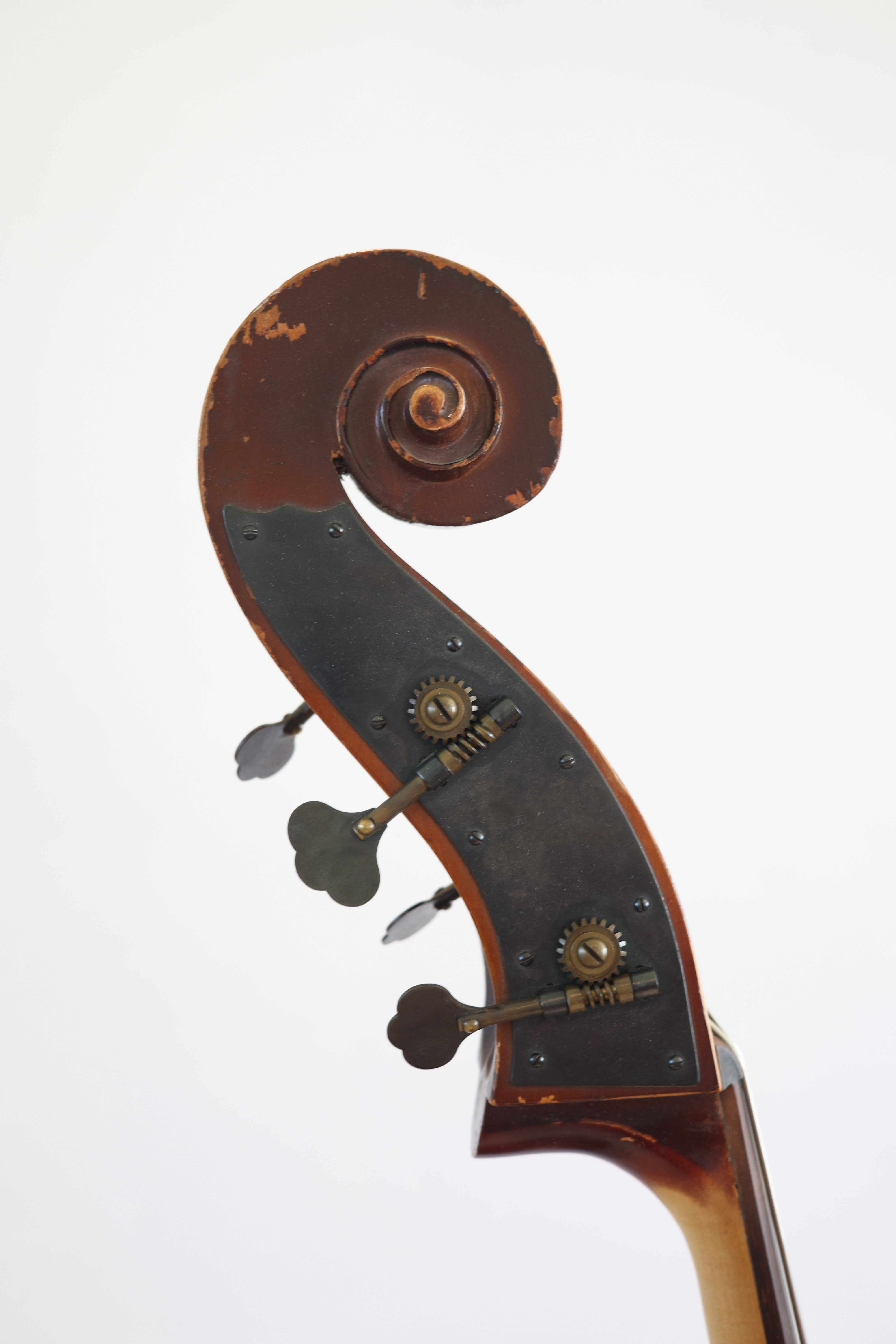 Close-up of the scroll of a double bass, showcasing the wooden texture and tuning pegs.